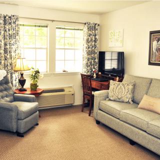Cozy living room with a sofa, armchair, and television.