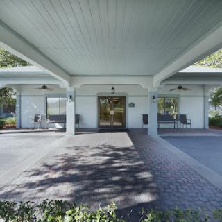A modern commercial building entrance with a spacious outdoor area.