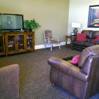 A cozy living room setup featuring brown leather furniture and a television.