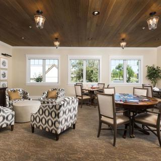 A cozy living room with patterned armchairs, tables, and decorative lighting.