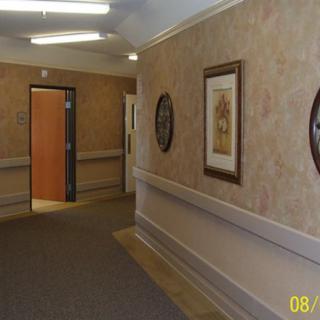 A decorated hallway with framed artwork and open doorways.