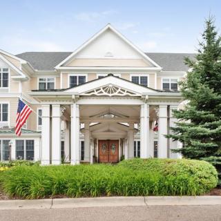 A stately building with a grand entrance featuring columns and an American flag displayed outside.