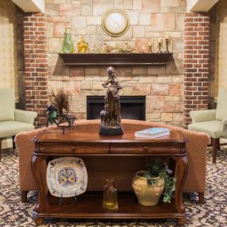 A cozy living room with a brick fireplace, elegant decor, and comfortable seating.
