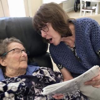 A heartfelt moment shared between a caregiver and an elderly woman, highlighting the importance of connection and companionship.