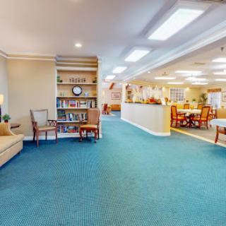 A welcoming interior lobby featuring comfortable seating and a bookshelf, perfect for relaxing or reading.