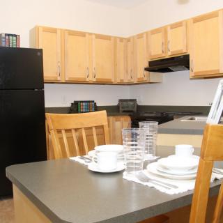 A cozy kitchen with wooden cabinets and a dining table set for a meal.