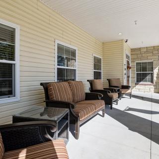 A cozy outdoor porch with comfortable seating and windows.