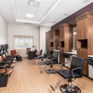 Interior view of a modern barber shop with chairs and mirrors.