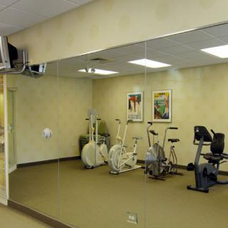 Small gym room with stationary bikes and mirrored wall.