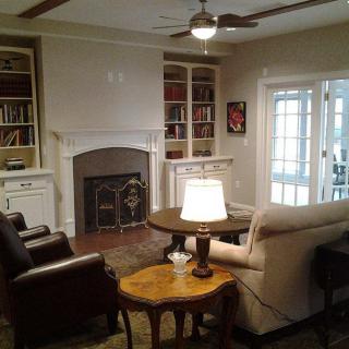 A cozy living room with a fireplace and bookshelves.
