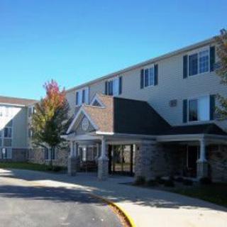 A residential building with a covered entrance and clear blue sky.