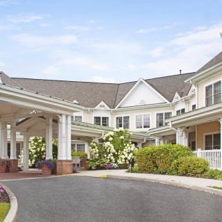 A well-maintained residential building with a covered entrance and landscaped surroundings.