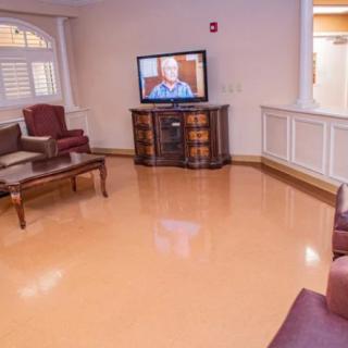 A cozy waiting room with seating and a television.