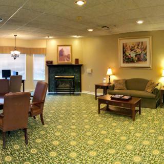 A cozy living room with a fireplace, comfortable seating, and decorative artwork.