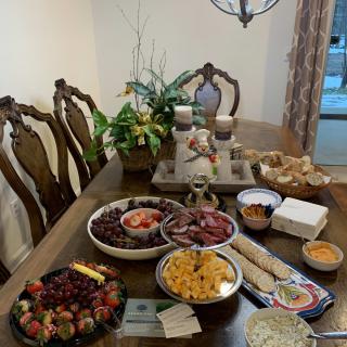 A beautifully set dining table with a variety of snacks and fruits, ready for guests.