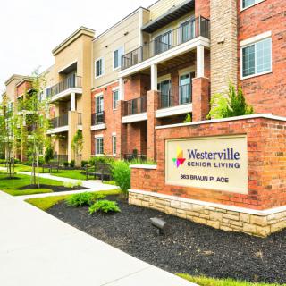 Exterior view of a senior living apartment complex with landscaped surroundings.
