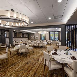 Elegant restaurant interior with neatly arranged tables and modern chandeliers.