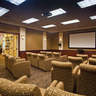 A cozy home theater room with comfortable seating and a large projector screen.
