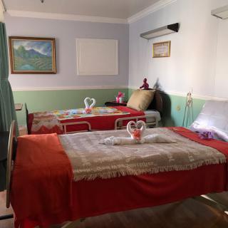 A cozy bedroom featuring two neatly arranged twin beds with decorative towel arrangements and art on the wall.