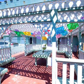 A vibrant outdoor patio adorned with colorful decorations, casting intricate shadows on the ground.