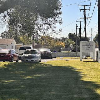 A view of a residential area with parked cars and a sign in the distance.