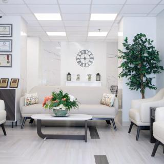 A modern lounge area with comfortable seating, decorative accents, and a wall clock.