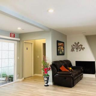A modern living room with a black sofa, decorative wall art, and a cozy fireplace.