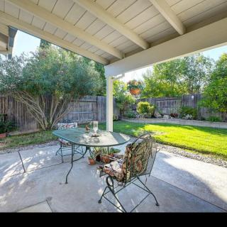 A cozy backyard patio with outdoor seating overlooking a lush garden.