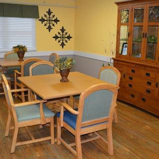 A cozy dining room with a wooden table, chairs, and a cabinet.