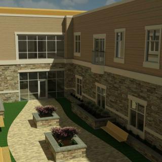 A modern courtyard featuring a paved path, benches, and planters, surrounded by an architecturally designed building exterior.