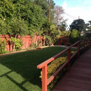 A well-maintained backyard garden with a green lawn and wooden fence.