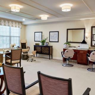 A well-appointed salon interior with chairs and mirrors, featuring elegant decor and lighting.