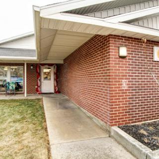 A welcoming entrance with a brick exterior and a pathway leading to the door.