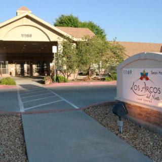 The entrance of a commercial building with landscaped surroundings.