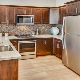 A modern kitchen with stainless steel appliances and wooden cabinets.