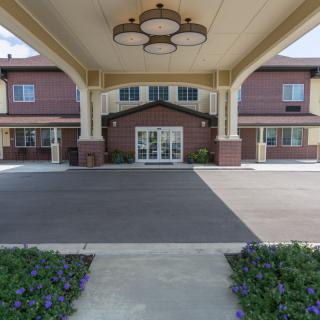 A residential building entrance with a covered pathway and landscaped surroundings.