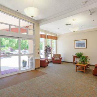 A spacious lobby with comfortable seating, natural light, and plants.