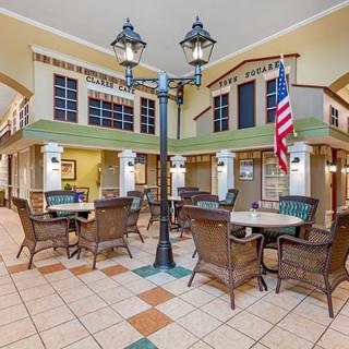 A spacious indoor seating area with wicker chairs, tables, a lamppost, and an American flag.
