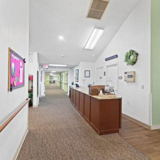 A well-lit hallway with a reception desk and decorative elements on the walls.