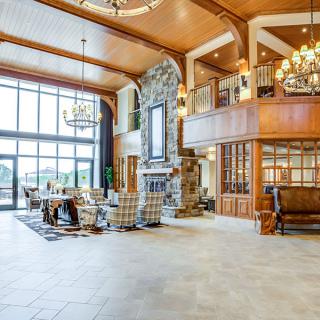 Spacious lobby with elegant interior design, featuring a large stone fireplace and chandelier.