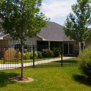 A suburban house with a fenced yard and landscaped garden.
