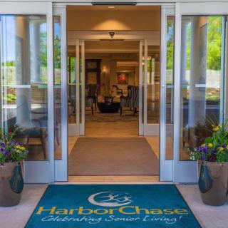 Entrance to a building with glass doors and a welcome mat.