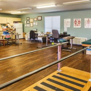A physical therapy room equipped with parallel bars and rehabilitation tools.