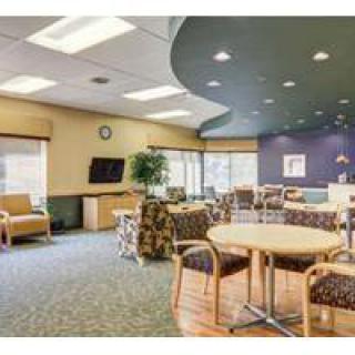 A spacious waiting area with comfortable seating and a television.