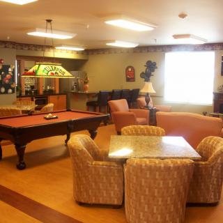 A cozy game room featuring a pool table and comfortable seating area.