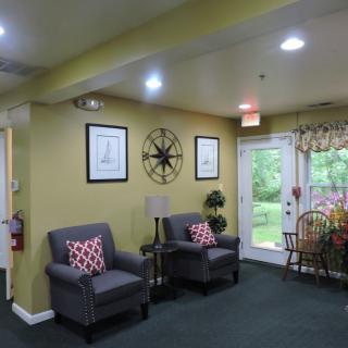 A cozy living room with armchairs and decorative elements.