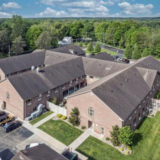 Aerial view of a residential brick apartment complex with surrounding greenery.