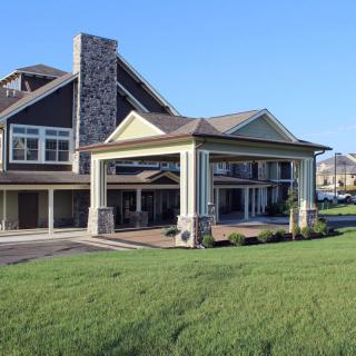 A modern residential building with a well-maintained lawn in the foreground.