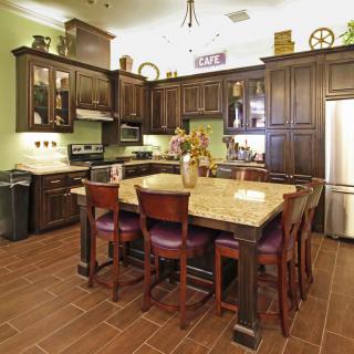 A spacious kitchen with dark wood cabinets and a large island.