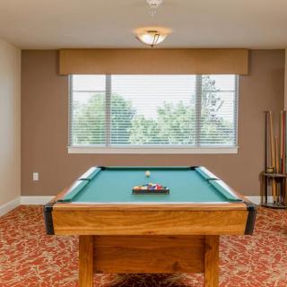 A spacious game room featuring a pool table and cue sticks.